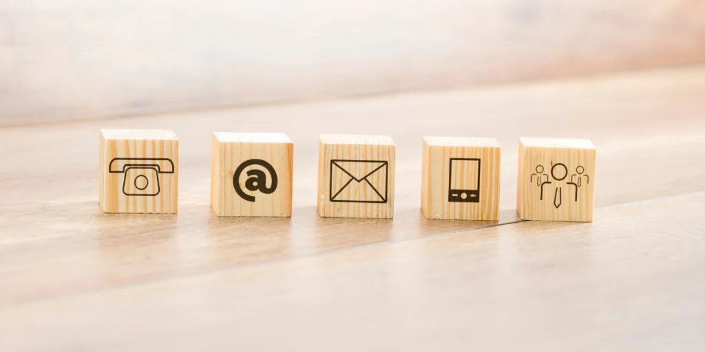 Iconos de contacto: teléfono, correo electrónico, email, celular y asesoría, sobre cubos de madera